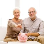 gettyimages 481744096 senior couple with piggy bank scaled 1