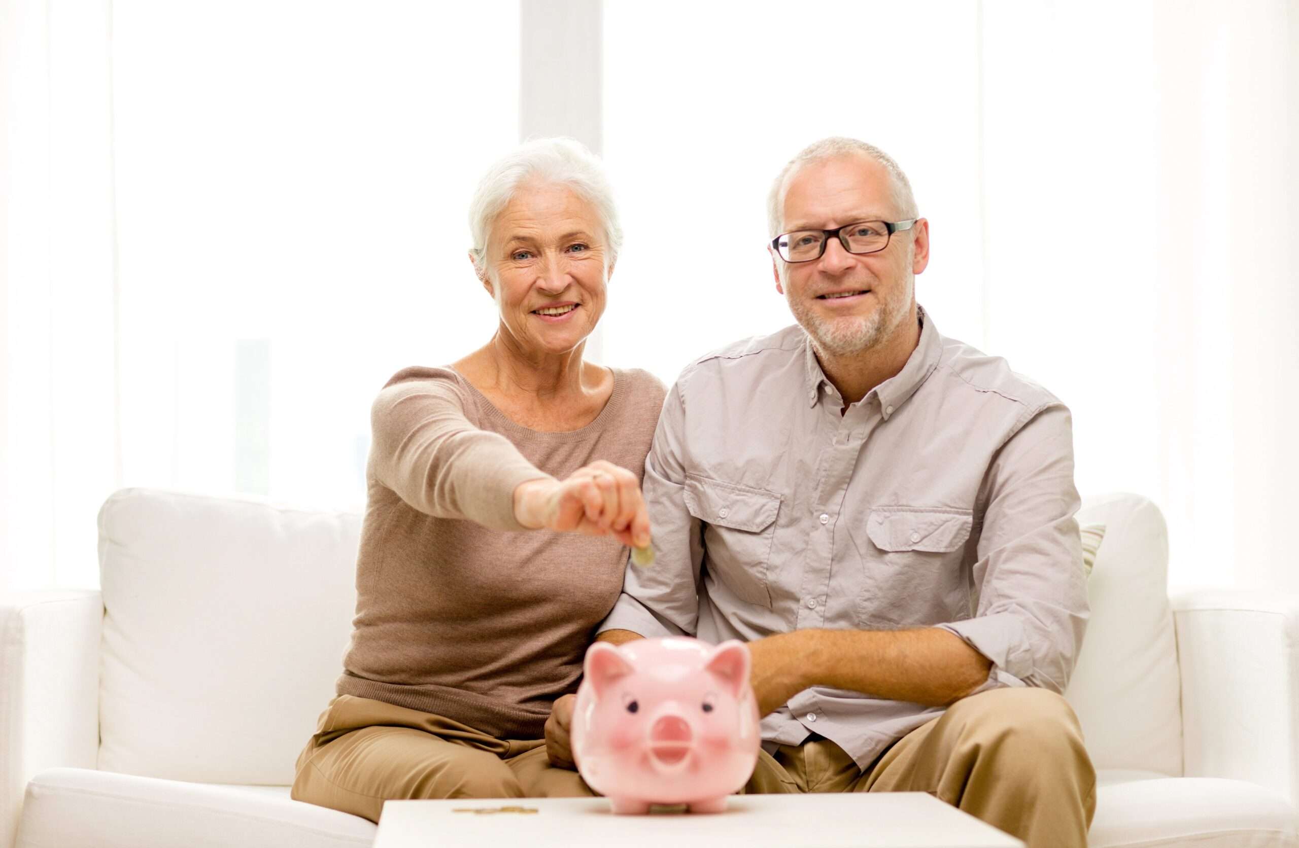 gettyimages 481744096 senior couple with piggy bank scaled 1